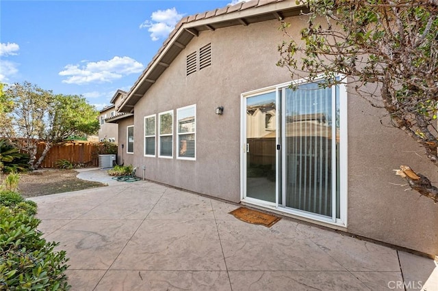 rear view of property with central AC and a patio