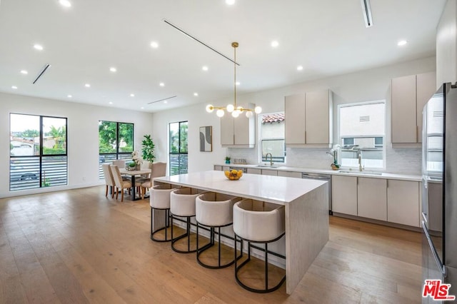 kitchen featuring a center island, pendant lighting, a kitchen breakfast bar, and light hardwood / wood-style floors