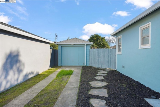 view of yard featuring a garage and an outbuilding