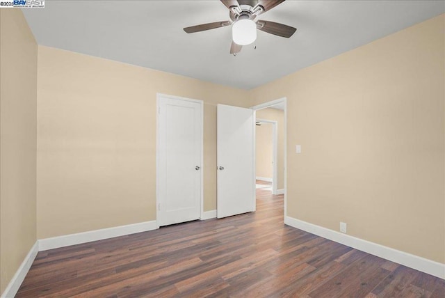 unfurnished room with dark wood-type flooring and ceiling fan