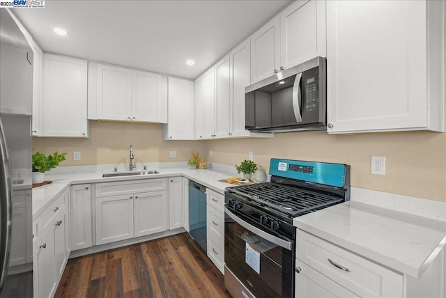 kitchen featuring sink, dark wood-type flooring, appliances with stainless steel finishes, light stone counters, and white cabinets