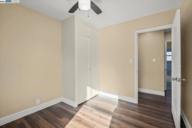 empty room with dark wood-type flooring and ceiling fan