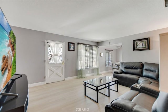 living room with ceiling fan and light wood-type flooring