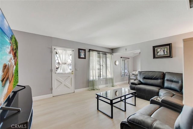 living room with baseboards and light wood-style flooring