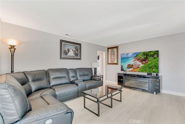 living area featuring visible vents, light wood-type flooring, and baseboards