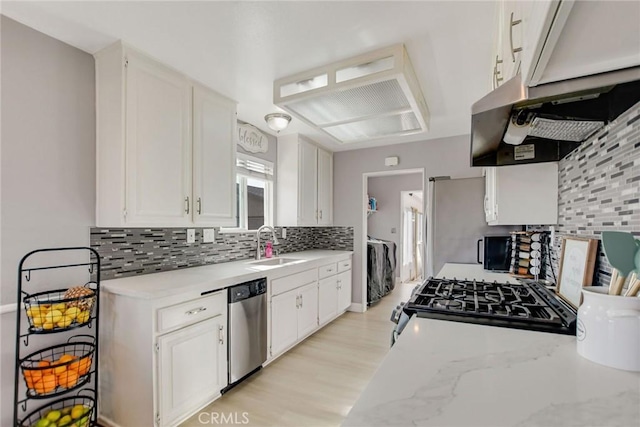 kitchen with black gas range, a sink, stainless steel dishwasher, white cabinetry, and decorative backsplash