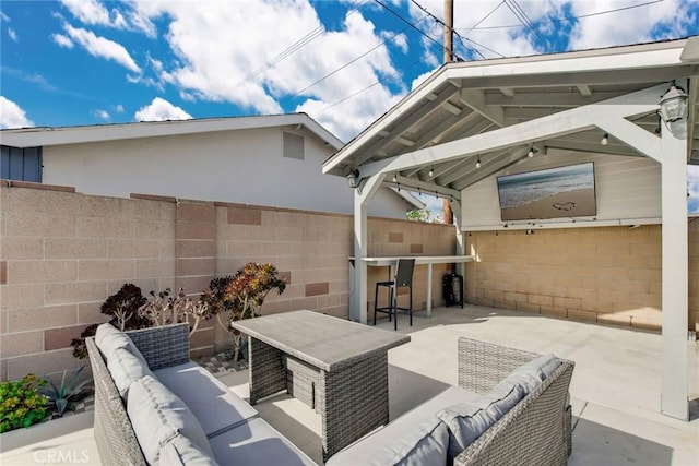 view of patio / terrace with outdoor dry bar, outdoor lounge area, a gazebo, and a fenced backyard