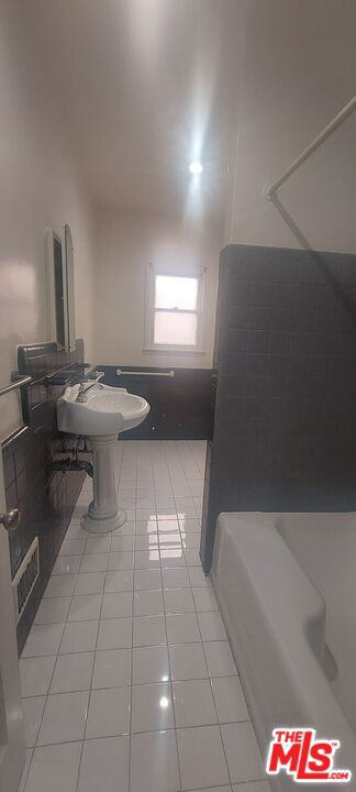 bathroom with tile patterned flooring, sink, and a washtub