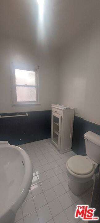 bathroom featuring toilet and tile patterned flooring