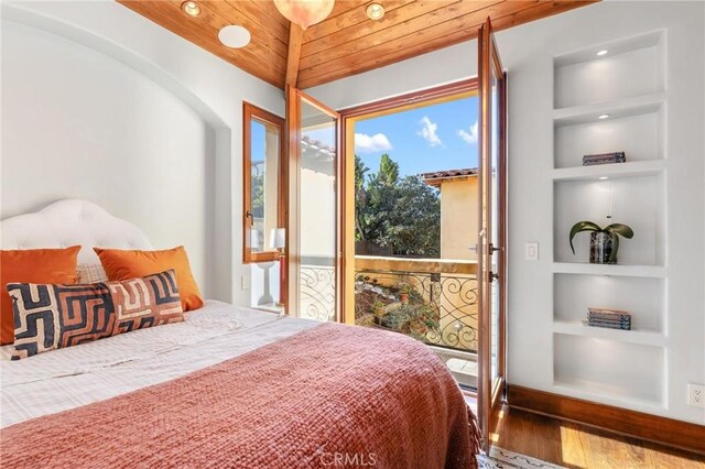 bedroom featuring lofted ceiling, hardwood / wood-style floors, and wooden ceiling