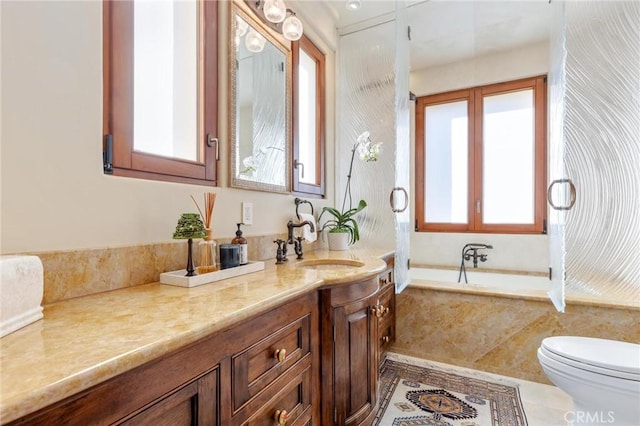 bathroom with vanity, a relaxing tiled tub, and toilet