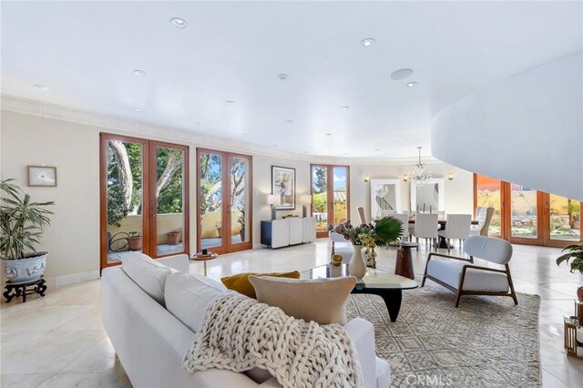 living room featuring crown molding, french doors, and a notable chandelier