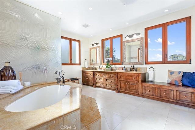 bathroom featuring vanity, tiled tub, and tile patterned floors