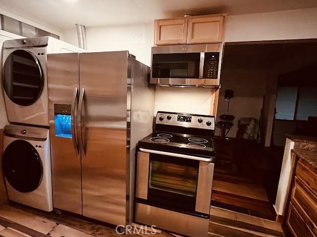 kitchen featuring stacked washer / drying machine, stainless steel appliances, and light brown cabinets