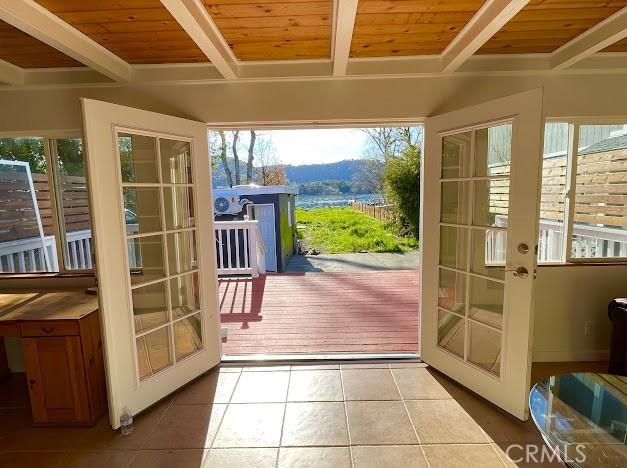 doorway to outside with french doors, tile patterned floors, and wooden ceiling