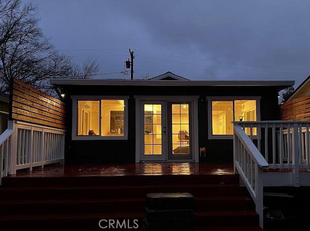 back of house with a wooden deck and french doors