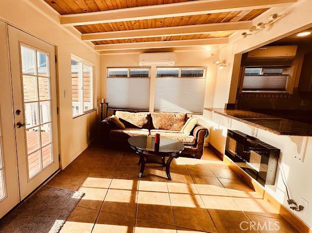 interior space featuring a wall mounted air conditioner, beam ceiling, and wooden ceiling