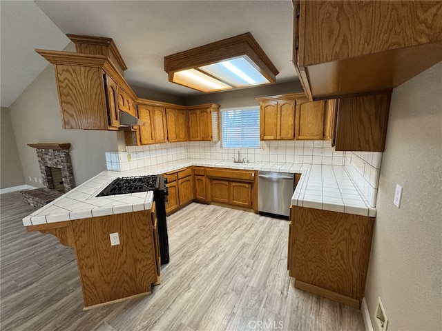 kitchen featuring tasteful backsplash, tile counters, kitchen peninsula, and appliances with stainless steel finishes