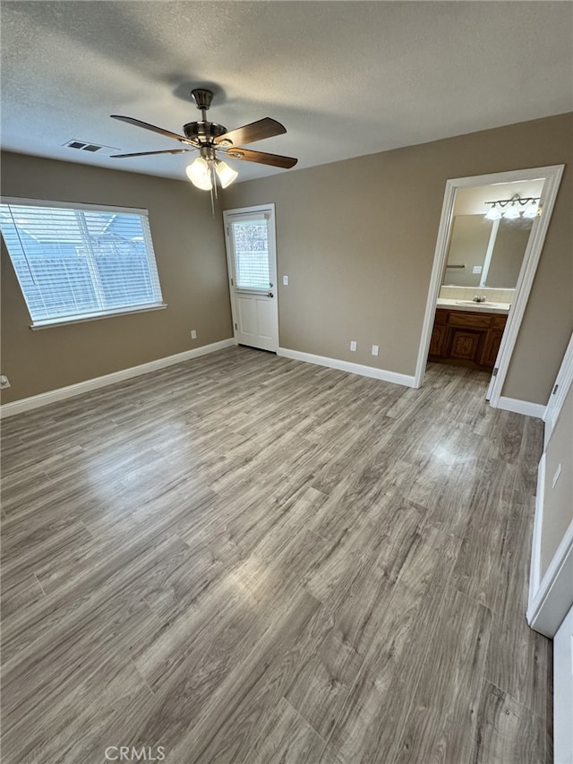 interior space featuring a textured ceiling, ceiling fan, and light hardwood / wood-style flooring