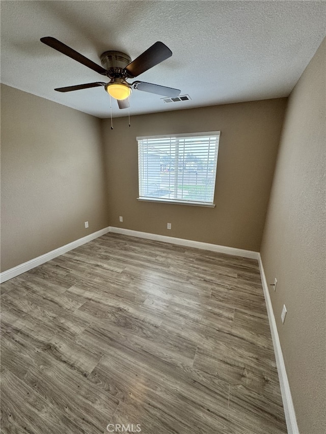 empty room featuring ceiling fan, a textured ceiling, and light wood-type flooring