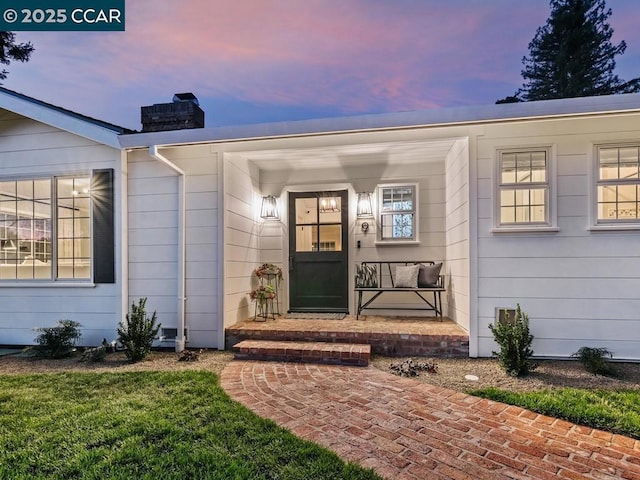 exterior entry at dusk with a lawn