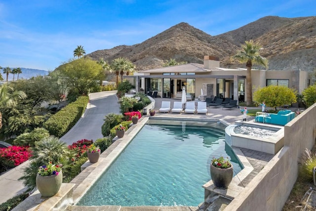 view of swimming pool with a mountain view and a patio area