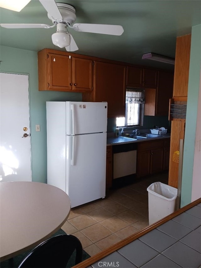 kitchen with sink, light tile patterned floors, white refrigerator, dishwasher, and ceiling fan