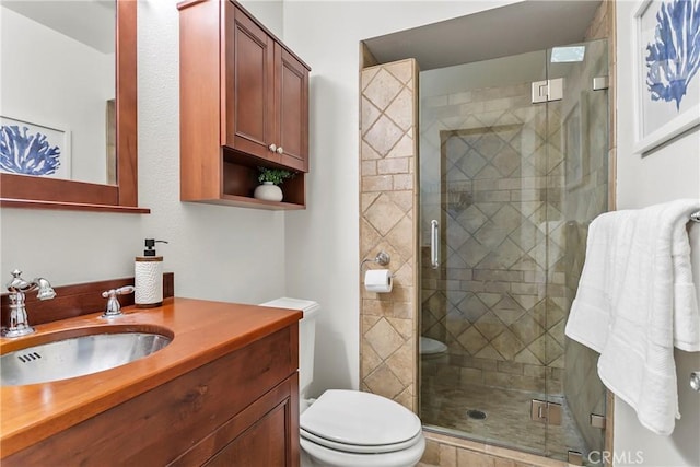 bathroom featuring vanity, toilet, and a shower with shower door