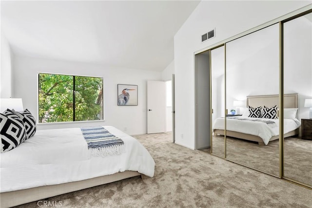 bedroom with lofted ceiling, light colored carpet, and a closet