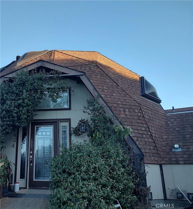 view of side of property featuring a shingled roof