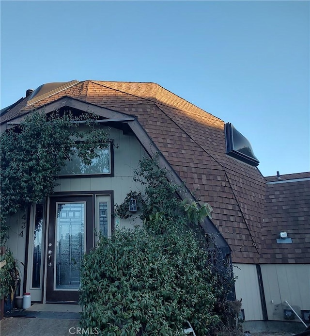 view of property exterior with roof with shingles