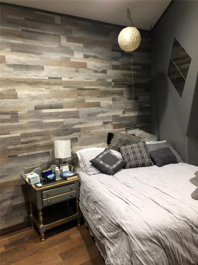 bedroom with wood finished floors and wood walls