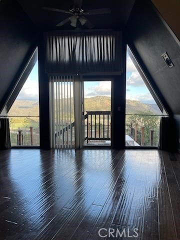 bonus room featuring wood finished floors, a ceiling fan, and a healthy amount of sunlight