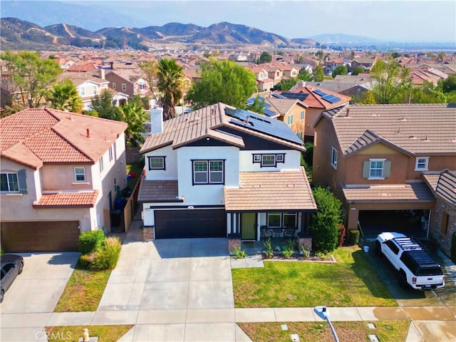 view of front of home with a mountain view, a garage, and a front lawn