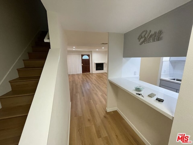 corridor featuring sink and light hardwood / wood-style flooring