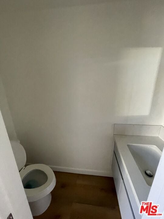 bathroom featuring vanity, hardwood / wood-style floors, and toilet