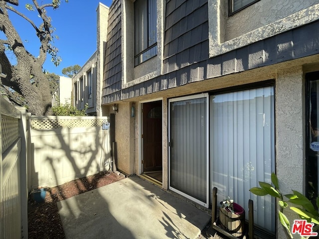 view of exterior entry with a patio area