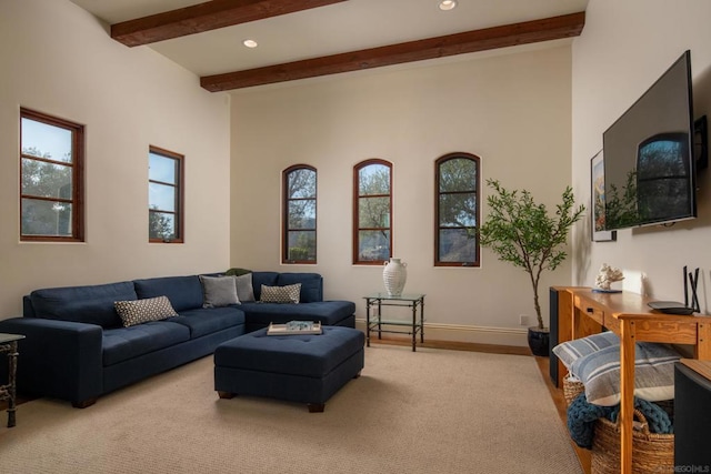 living room with light colored carpet, beam ceiling, and a wealth of natural light