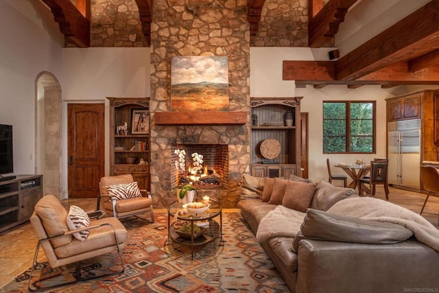 living room with a stone fireplace and a high ceiling