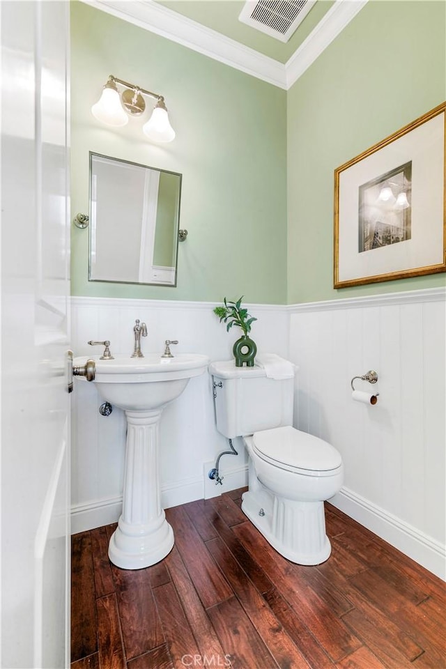 bathroom with crown molding, hardwood / wood-style floors, and toilet