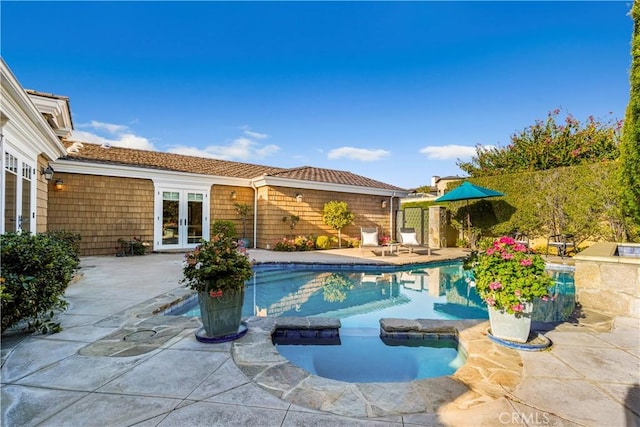 view of swimming pool with a patio and french doors