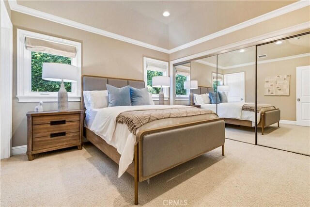 bedroom with multiple windows, light carpet, and a closet