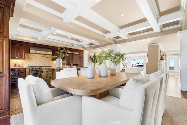 dining room with crown molding, coffered ceiling, dark hardwood / wood-style flooring, and beamed ceiling