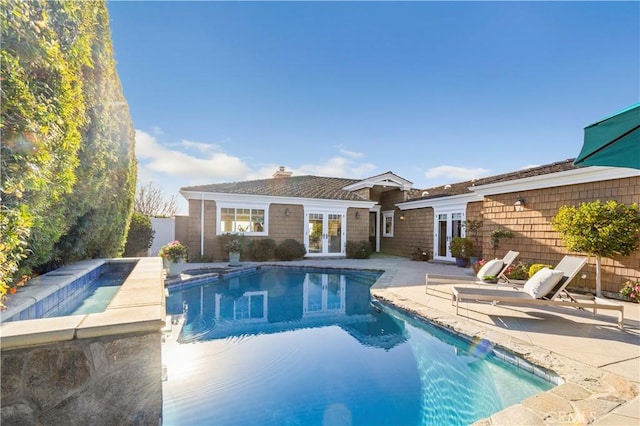 view of swimming pool featuring french doors, a patio, and an outbuilding