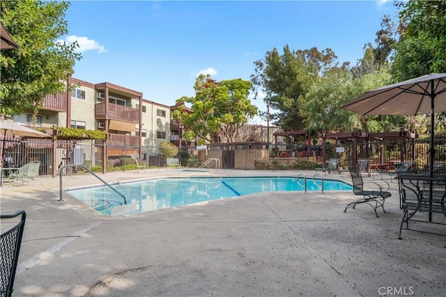 community pool featuring a patio area and fence