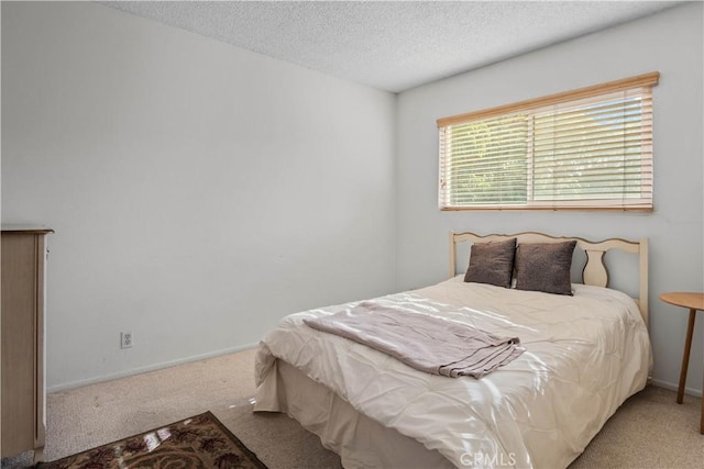 bedroom with baseboards, carpet, and a textured ceiling