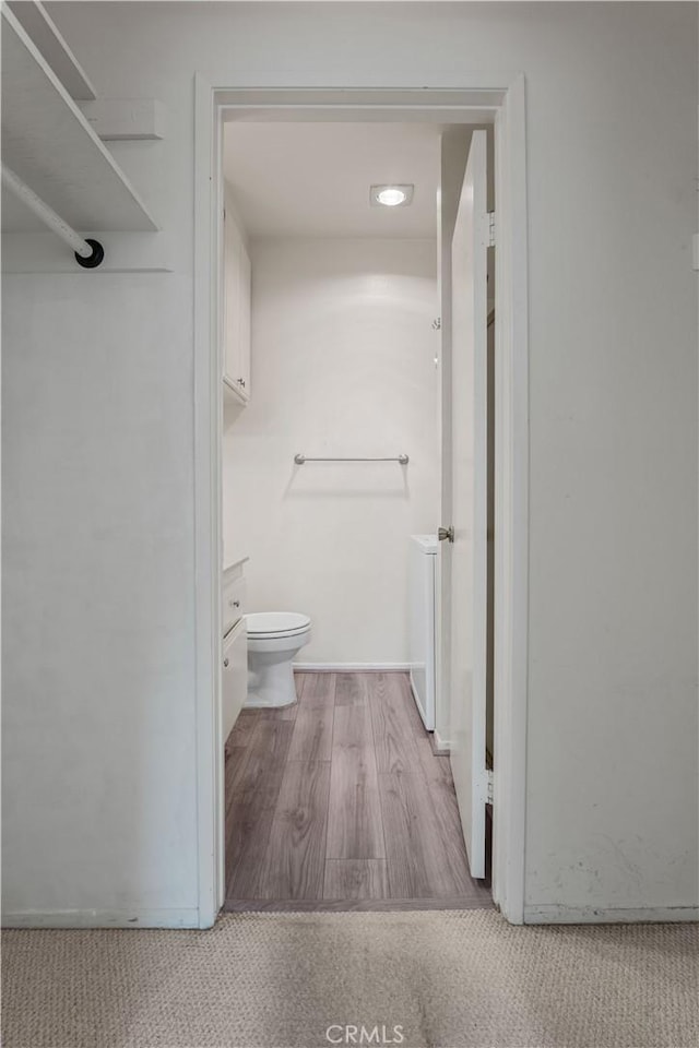 bathroom featuring toilet and wood finished floors