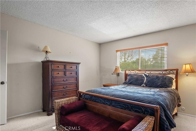 bedroom featuring baseboards, light colored carpet, and a textured ceiling