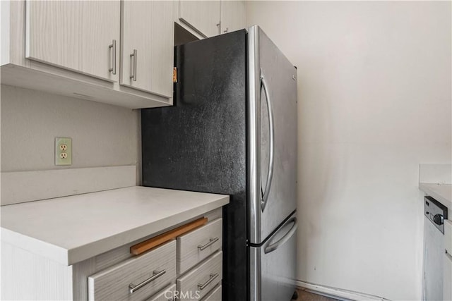 kitchen featuring light countertops and freestanding refrigerator