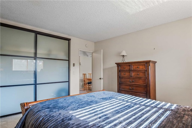 carpeted bedroom featuring a closet and a textured ceiling